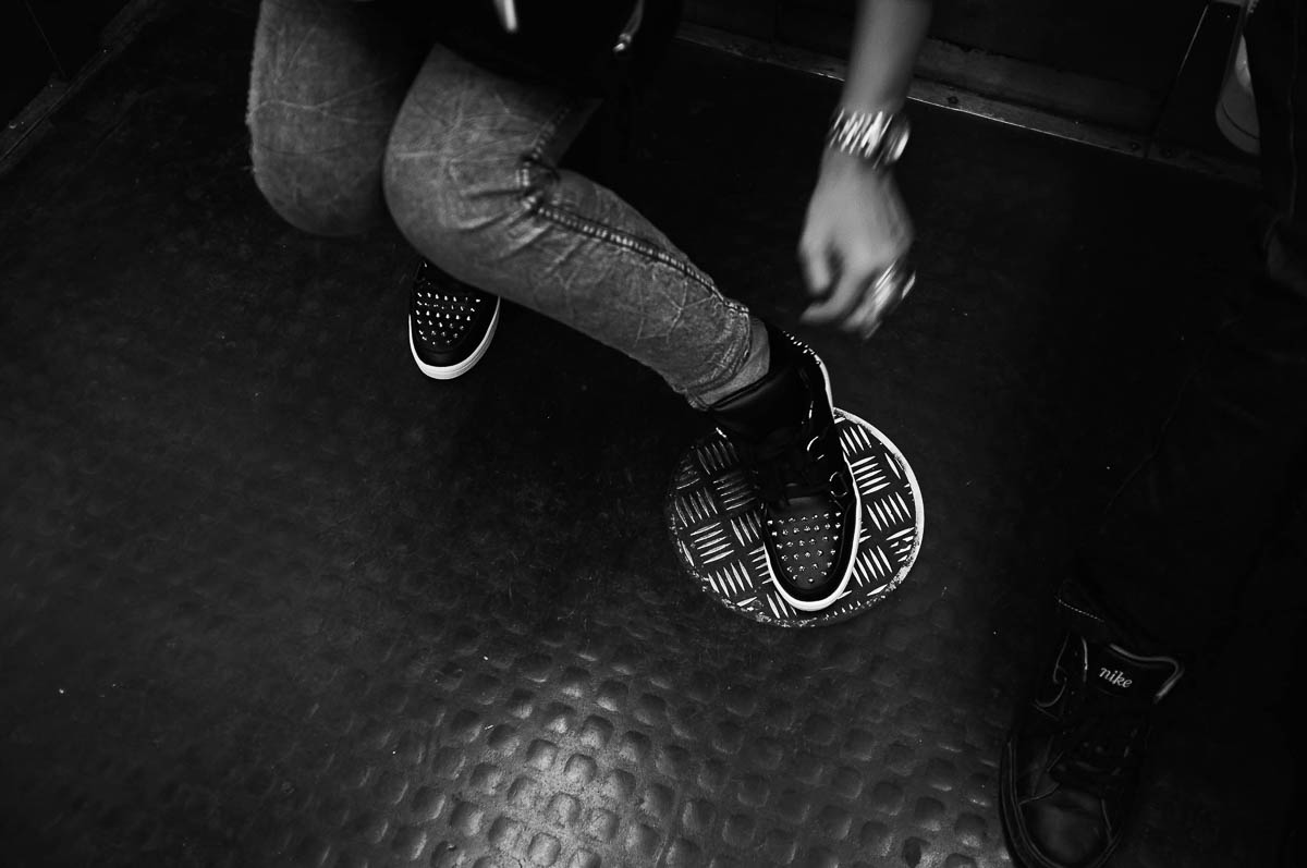 A young woman wearing black studded sneakers on the Paris metro, from the series Going Underground by Emmanuel Pineau